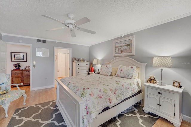501 Lakeside Dr Unit 501, Bradenton, FL 34210 - bedroom with a textured ceiling, crown molding, light wood finished floors, and visible vents