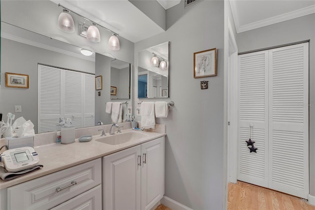 501 Lakeside Dr Unit 501, Bradenton, FL 34210 - bathroom with crown molding, a closet, vanity, wood finished floors, and baseboards