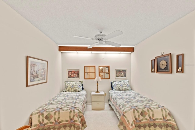 carpeted bedroom with a ceiling fan and a textured ceiling