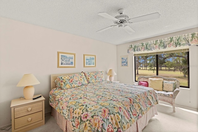 carpeted bedroom featuring access to outside, a textured ceiling, and ceiling fan