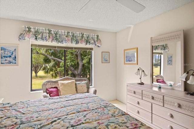 bedroom with a ceiling fan and a textured ceiling