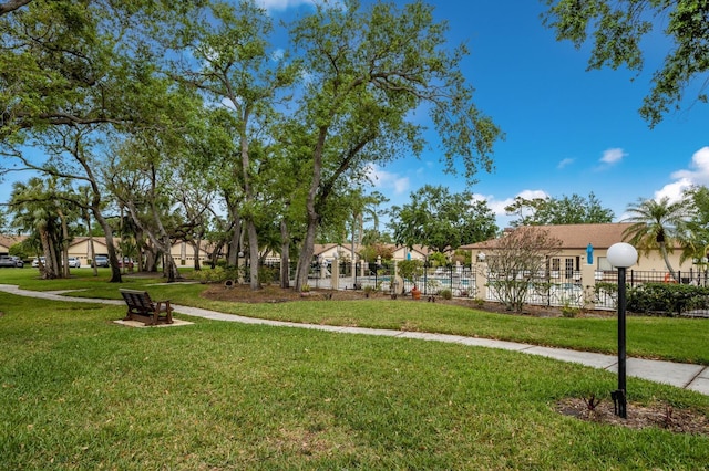 view of home's community featuring a lawn and fence