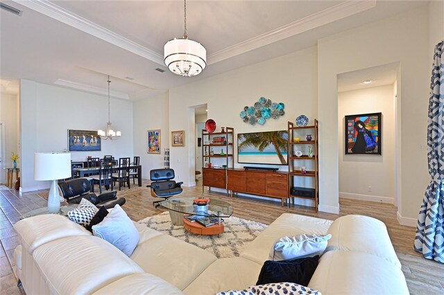 1017 Siberian Gln, Bradenton, FL 34212 - living area featuring a notable chandelier, a tray ceiling, crown molding, visible vents, and wood finished floors