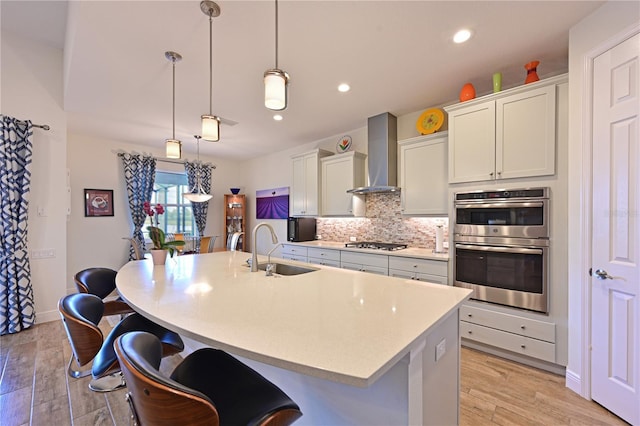 1017 Siberian Gln, Bradenton, FL 34212 - kitchen featuring a sink, stainless steel appliances, a center island with sink, wall chimney exhaust hood, and backsplash