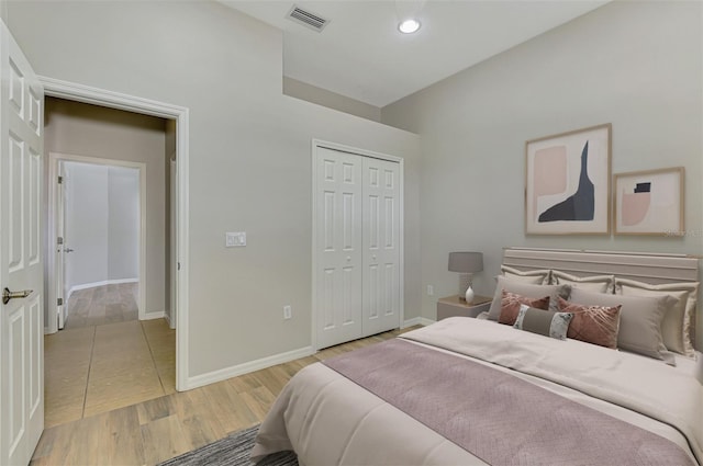 6310 Golden Eye Gln, Lakewood Ranch, FL 34202 - bedroom with baseboards, light wood-type flooring, a closet, and lofted ceiling