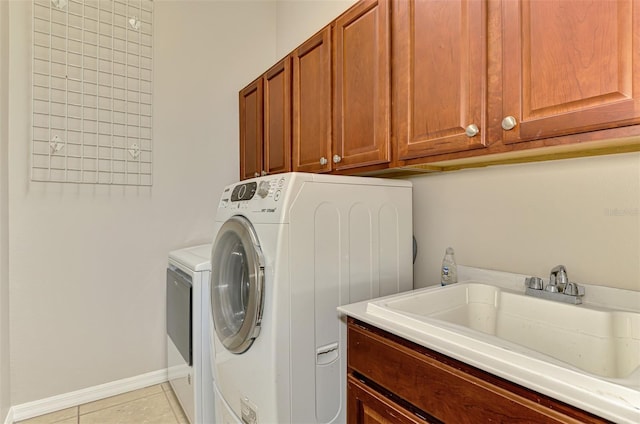 6310 Golden Eye Gln, Lakewood Ranch, FL 34202 - laundry area featuring cabinet space, washing machine and clothes dryer, light tile patterned flooring, and baseboards