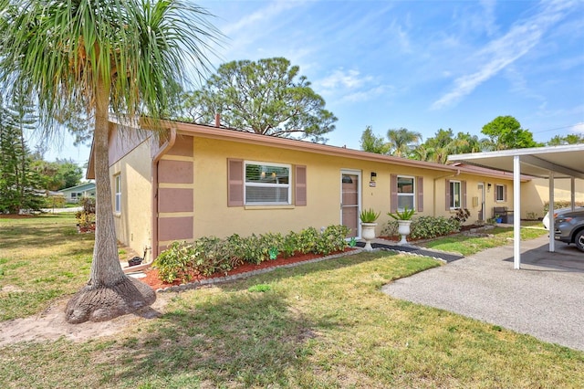 4420 Tecumseh Trl Unit 38, Sarasota, FL 34233 - ranch-style home with stucco siding, a front lawn, and a carport