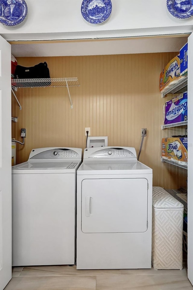 4420 Tecumseh Trl Unit 38, Sarasota, FL 34233 - laundry room with washer and clothes dryer and wood walls