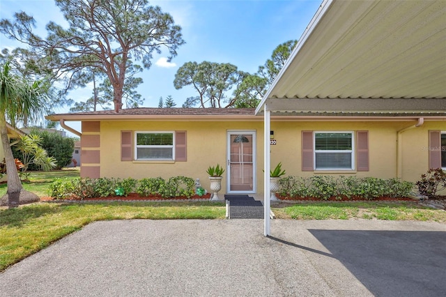 4420 Tecumseh Trl Unit 38, Sarasota, FL 34233 - view of front of house featuring stucco siding, a front yard, and a patio