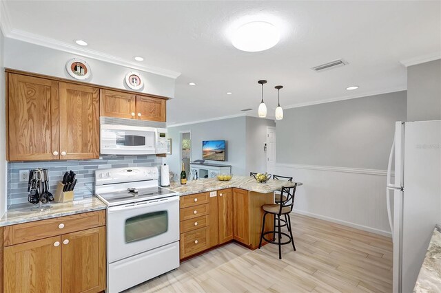 4420 Tecumseh Trl Unit 38, Sarasota, FL 34233 - kitchen featuring white appliances, a peninsula, crown molding, tasteful backsplash, and light wood-style floors