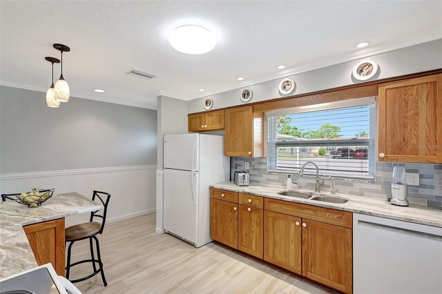 4420 Tecumseh Trl Unit 38, Sarasota, FL 34233 - kitchen featuring white appliances, a sink, brown cabinetry, backsplash, and light stone counters