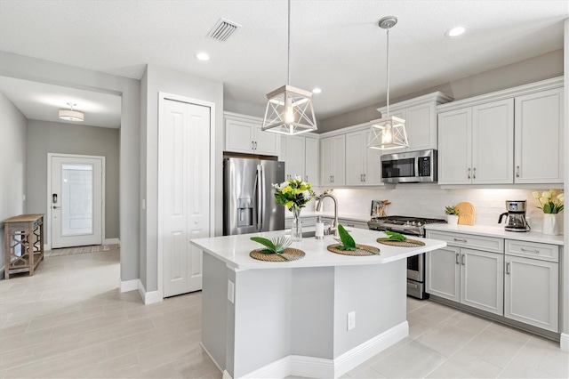 2894 Butterfly Jasmine Trl, Sarasota, FL 34240 - kitchen with appliances with stainless steel finishes, light countertops, tasteful backsplash, a center island with sink, and recessed lighting