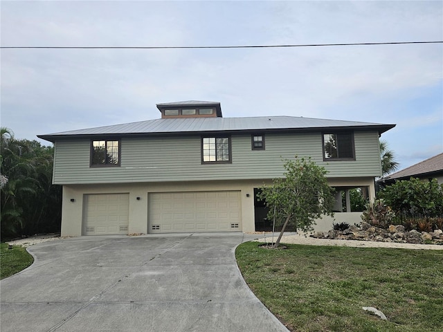 33 Tee View Pl, Rotonda West, FL 33947 - view of front of property featuring an attached garage, driveway, stucco siding, metal roof, and a front yard