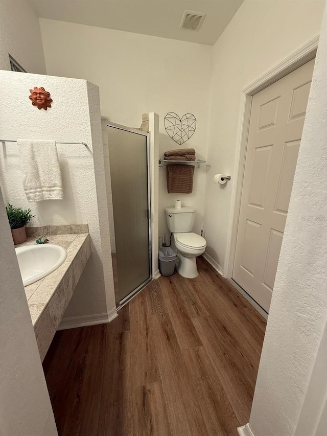 33 Tee View Pl, Rotonda West, FL 33947 - bathroom featuring a sink, a stall shower, wood finished floors, toilet, and baseboards