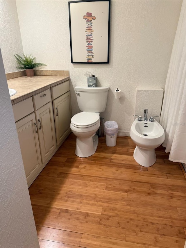 33 Tee View Pl, Rotonda West, FL 33947 - full bath featuring a textured wall, toilet, a bidet, wood finished floors, and vanity