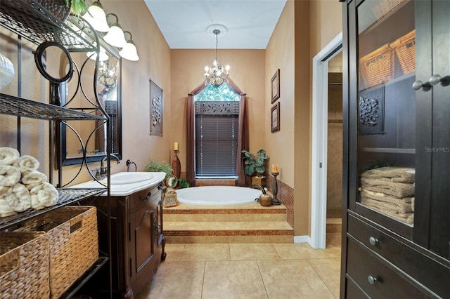 bathroom with tile patterned floors, a notable chandelier, vanity, and a bath