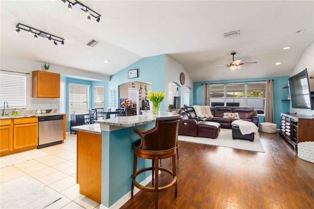 kitchen with vaulted ceiling, visible vents, dishwasher, and a healthy amount of sunlight