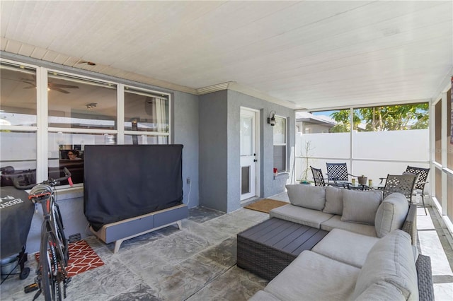 sunroom / solarium featuring an outdoor living space, ceiling fan, and a wall of windows