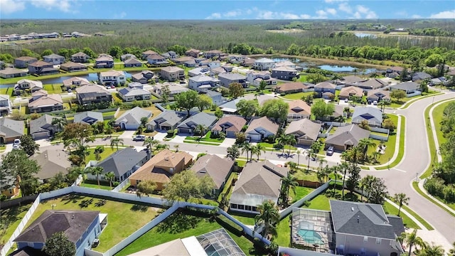 aerial view with a residential view, a water view, and a view of trees