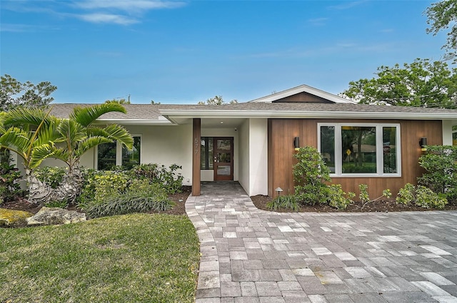 577 Corwood Dr, Sarasota, FL 34234 - view of front facade featuring french doors and roof with shingles