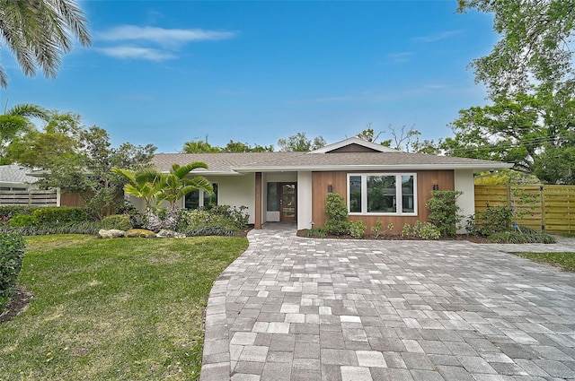 577 Corwood Dr, Sarasota, FL 34234 - ranch-style house featuring decorative driveway, a shingled roof, fence, and a front lawn