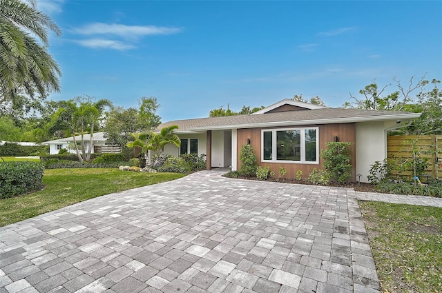 577 Corwood Dr, Sarasota, FL 34234 - single story home with decorative driveway, a front yard, fence, and stucco siding