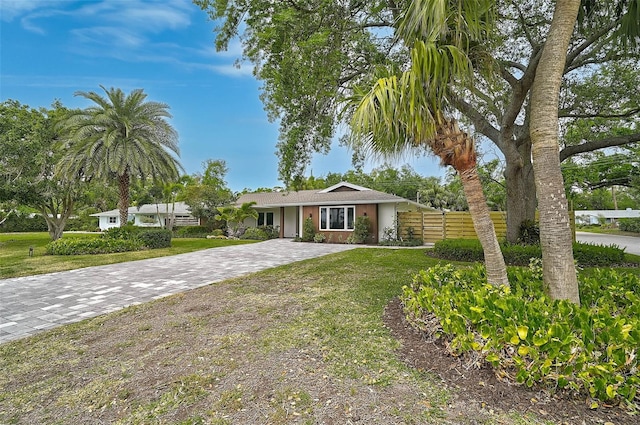 577 Corwood Dr, Sarasota, FL 34234 - view of front of property with a front yard, decorative driveway, stucco siding, and fence