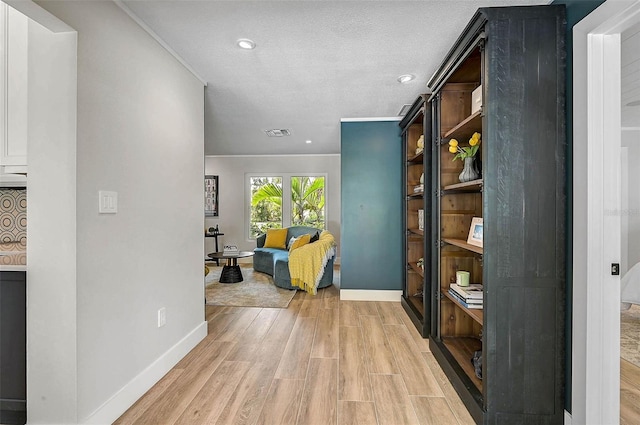 577 Corwood Dr, Sarasota, FL 34234 - hall featuring a textured ceiling, baseboards, visible vents, light wood-style floors, and recessed lighting