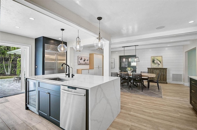 577 Corwood Dr, Sarasota, FL 34234 - kitchen featuring a sink, wine cooler, decorative light fixtures, and light wood-type flooring