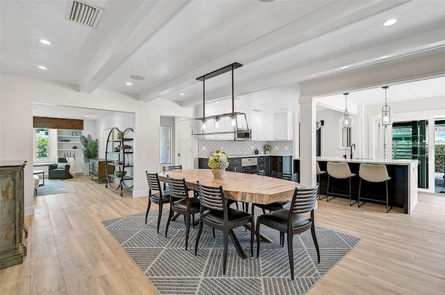 577 Corwood Dr, Sarasota, FL 34234 - dining area featuring light wood-style flooring, visible vents, a healthy amount of sunlight, and beam ceiling