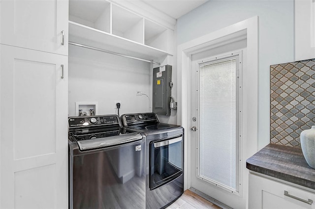 577 Corwood Dr, Sarasota, FL 34234 - clothes washing area with cabinet space, electric panel, washer and clothes dryer, and light wood finished floors
