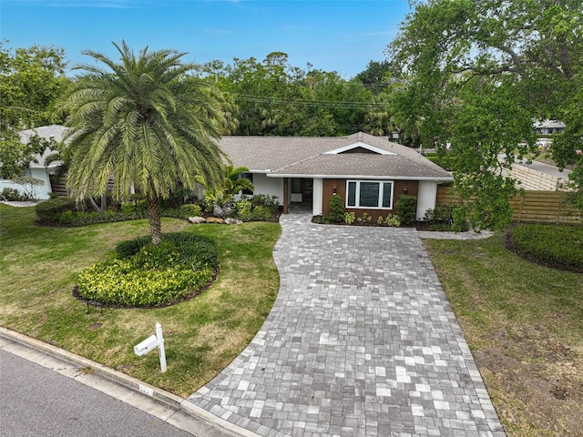 577 Corwood Dr, Sarasota, FL 34234 - view of front of home with stucco siding, roof with shingles, fence, driveway, and a front yard