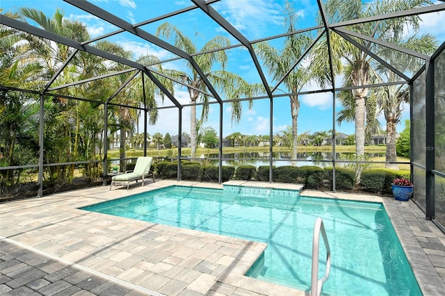 pool with a lanai, a water view, and a patio area