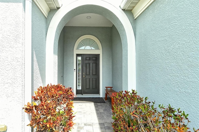 view of exterior entry with stucco siding