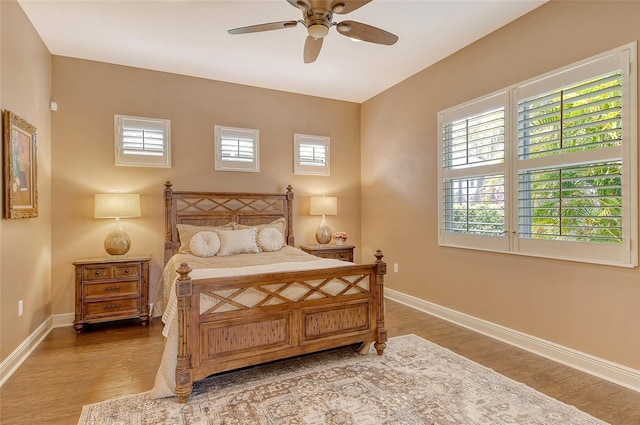 bedroom featuring baseboards, ceiling fan, and wood finished floors