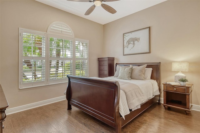 bedroom featuring baseboards, wood finished floors, and a ceiling fan