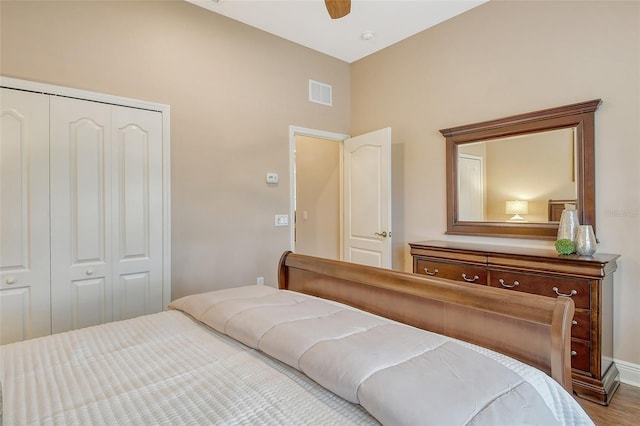 bedroom featuring a ceiling fan, wood finished floors, a closet, and visible vents