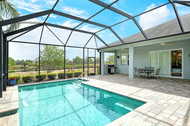 pool with glass enclosure, grilling area, a patio, and a ceiling fan