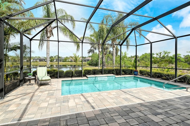 outdoor pool with glass enclosure, a water view, and a patio