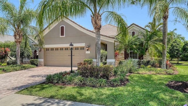 12041 Thornhill Ct, Lakewood Ranch, FL 34202 - view of front of house with an attached garage, stone siding, decorative driveway, and stucco siding