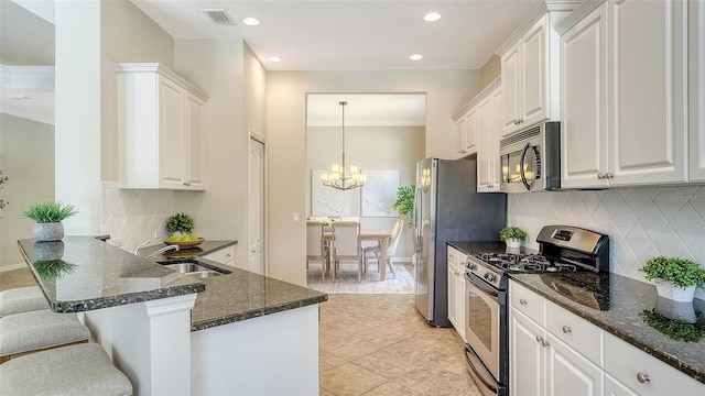 12041 Thornhill Ct, Lakewood Ranch, FL 34202 - kitchen featuring backsplash, white cabinets, visible vents, appliances with stainless steel finishes, and a sink