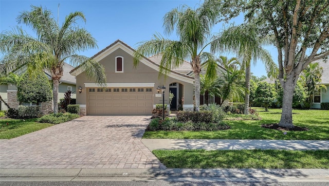 12041 Thornhill Ct, Lakewood Ranch, FL 34202 - view of front of home with stucco siding, decorative driveway, a front lawn, a garage, and a tiled roof