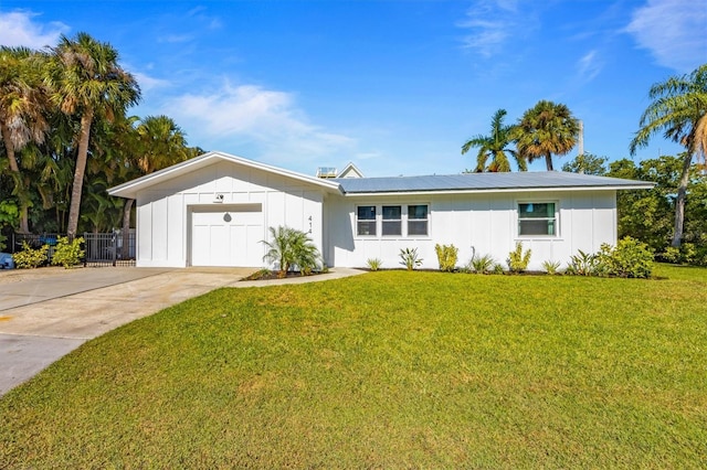 ranch-style home with board and batten siding, an attached garage, driveway, and a front lawn