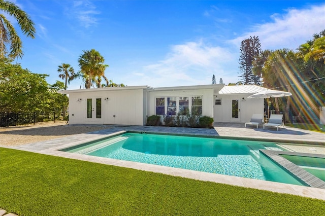 view of pool featuring a yard, a patio, a fenced in pool, and french doors