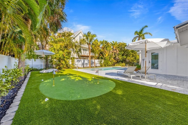 view of yard featuring a fenced in pool, a fenced backyard, and a patio area
