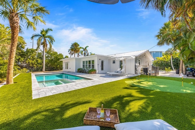outdoor pool featuring a lawn, a patio, and an in ground hot tub