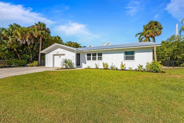 single story home with concrete driveway, board and batten siding, an attached garage, and a front yard