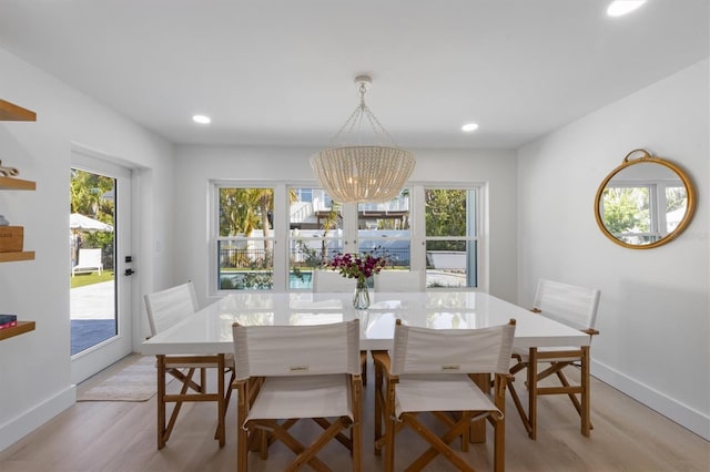 dining room featuring a chandelier, a wealth of natural light, and light wood-style floors