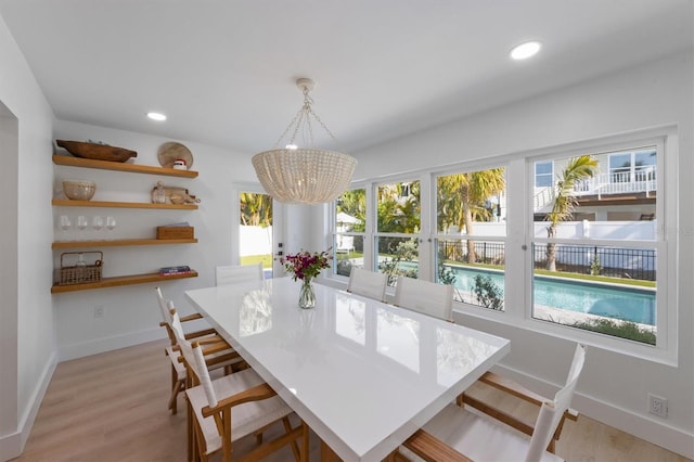 dining space with recessed lighting, baseboards, a notable chandelier, and light wood finished floors