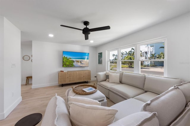 living area with baseboards, a ceiling fan, recessed lighting, and light wood-style flooring